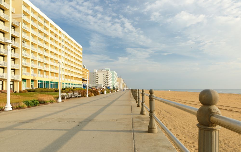 a beach side walkway with a hotel in the background